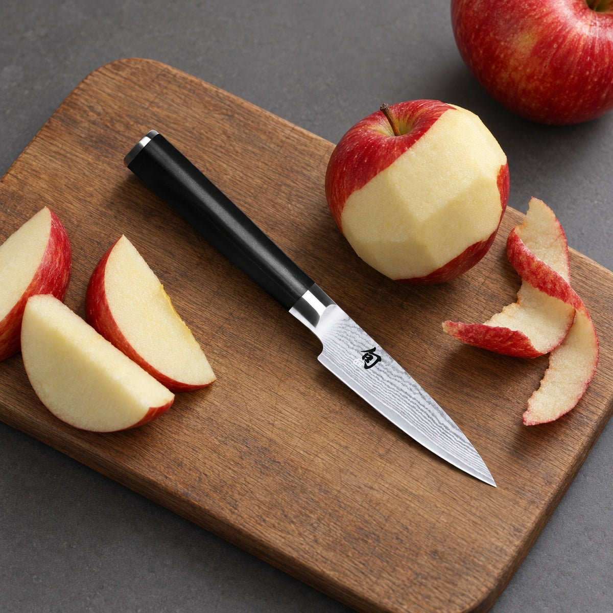 KAI Shun Classic DM-0700 mit vorbereitetem Apfel auf einem Holzbrett