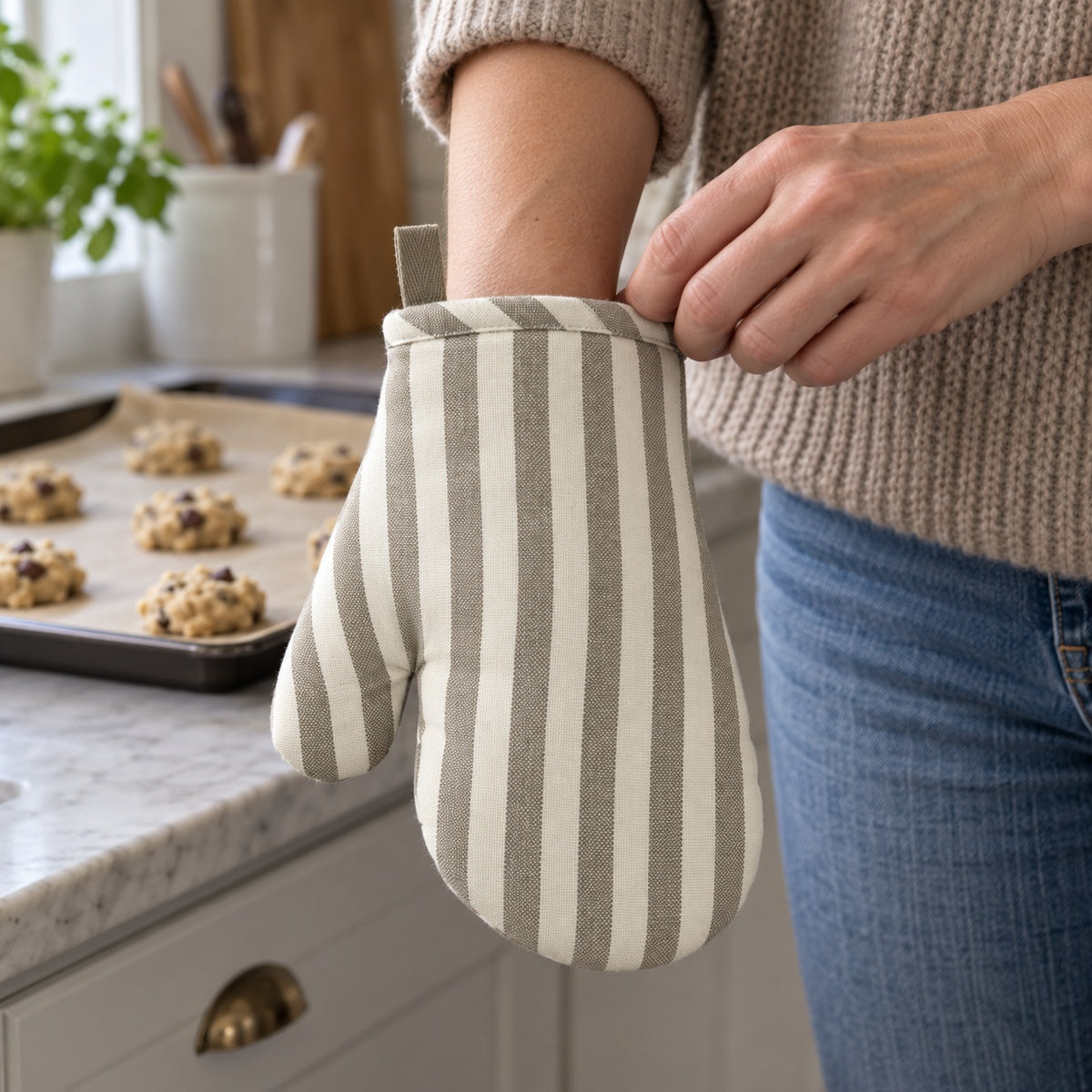 Södahl Harmony Mini-Ofenhandschuh in Taupe beim Anziehen vor dem Backen